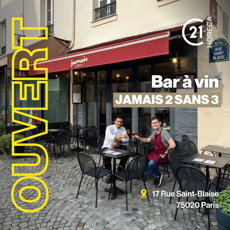 Parisian wine bar exterior with two men toasting at outdoor tables, wine glasses in hand, under a red awning.